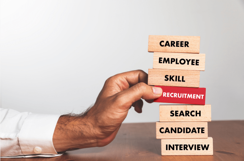 Hand pulling the Recruitment block from a stack of career, skill and interview blocks
